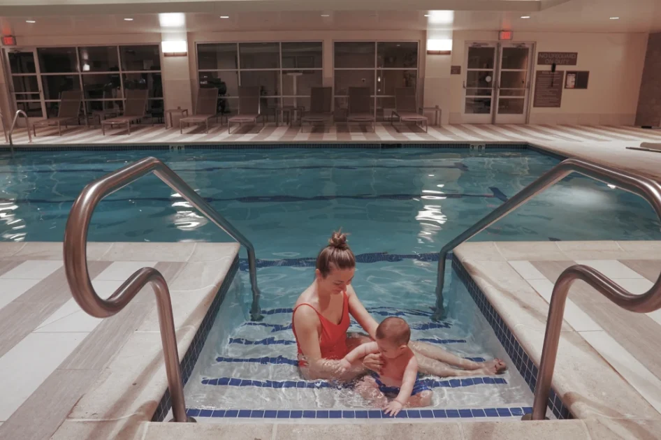 a woman in a red swimsuit and a baby boy hanging out in the pool at Doubletree by Hilton Reading Hotel