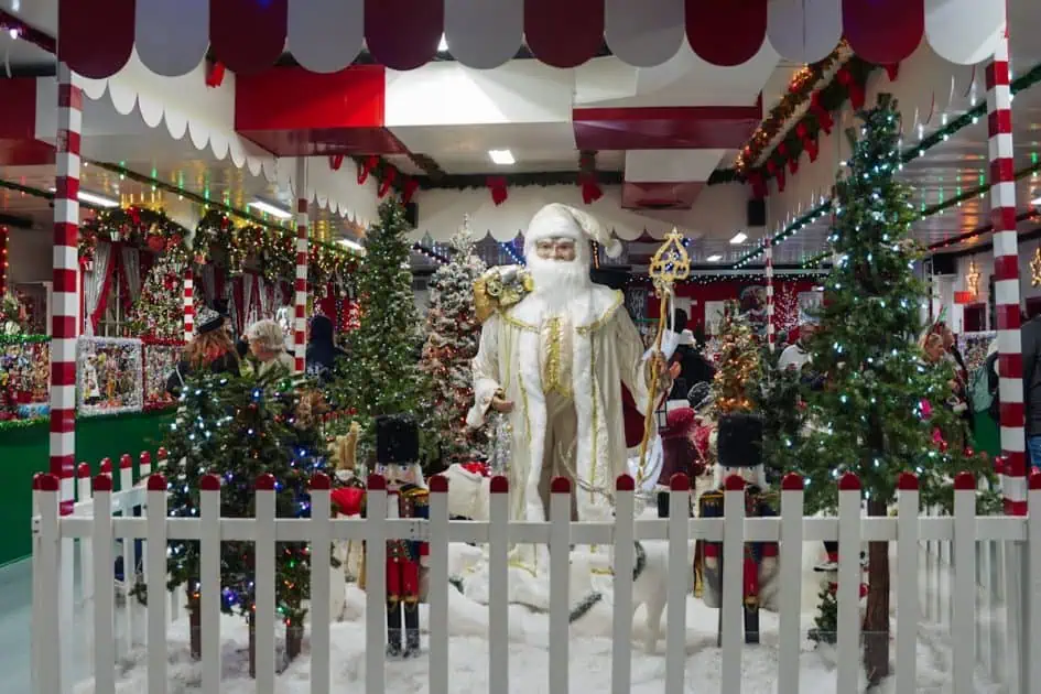 christmas gift and ornaments shop inside Koziars decorated with multiple christmas tree and Santa looking statue dressed in white and gold