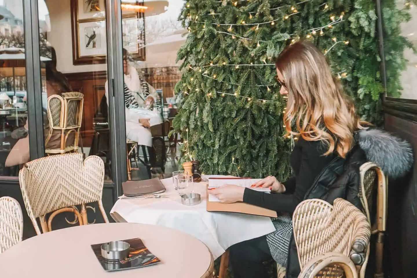 Girl looking at the menu in Paris Cafe Carette