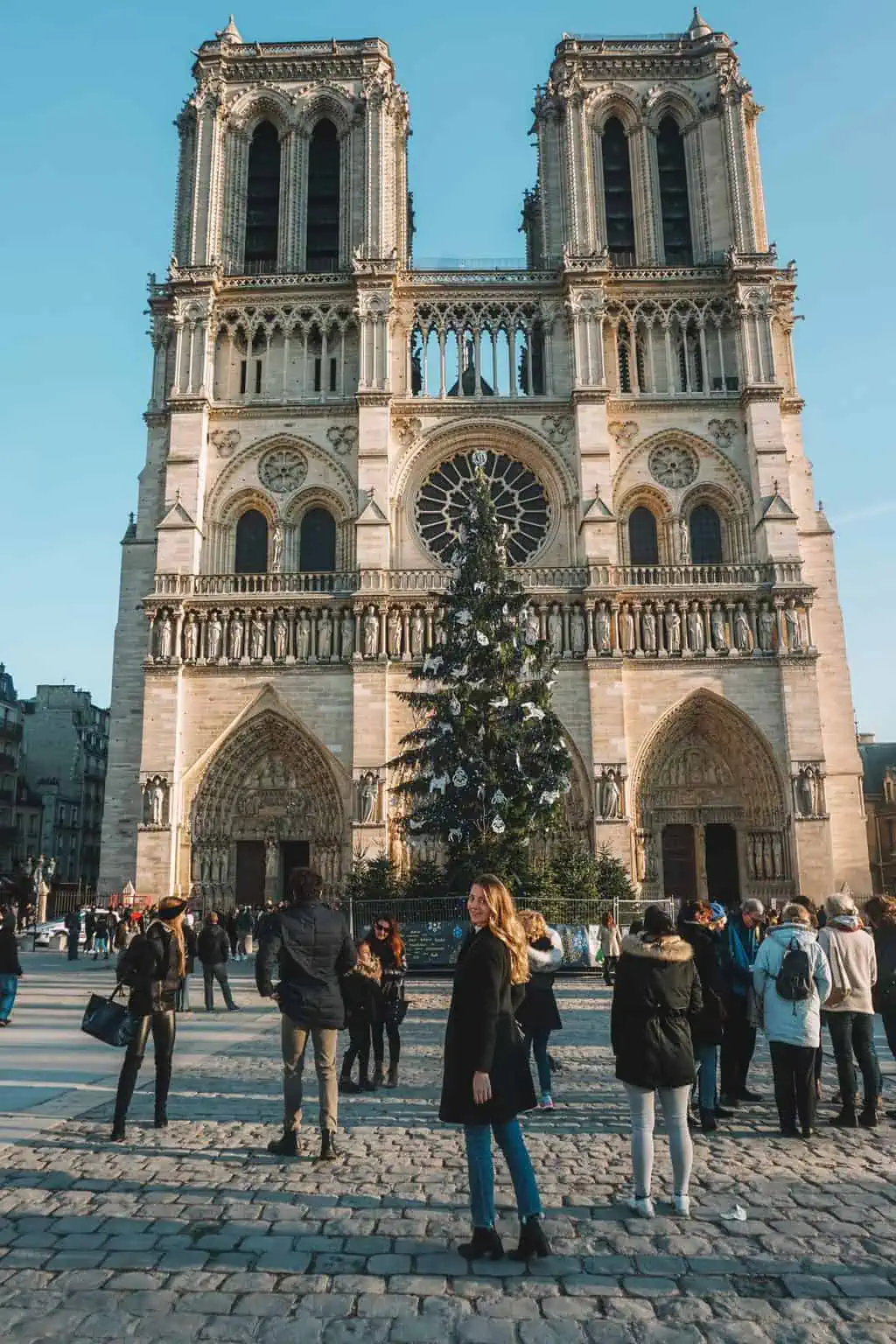 girl smiling in front of Notre Dame Cathedral Paris